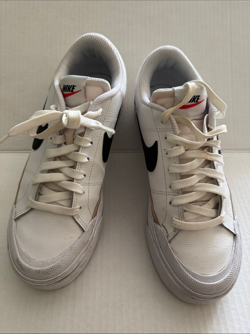 Nike White Low-Top Sneakers with Black Swoosh and Red Tongue Detail